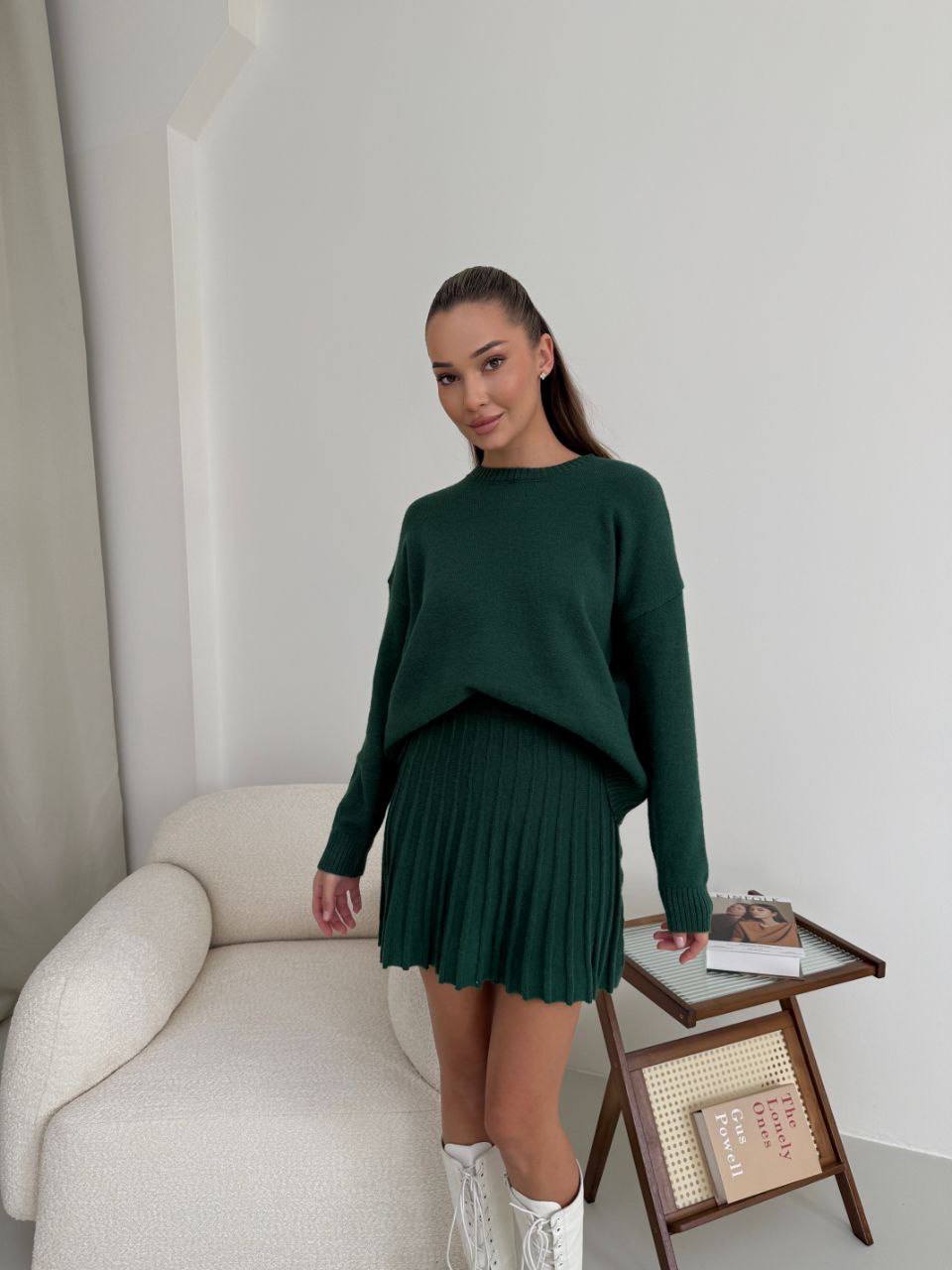 Kostým, který se skládá ze svetru a plisované sukně