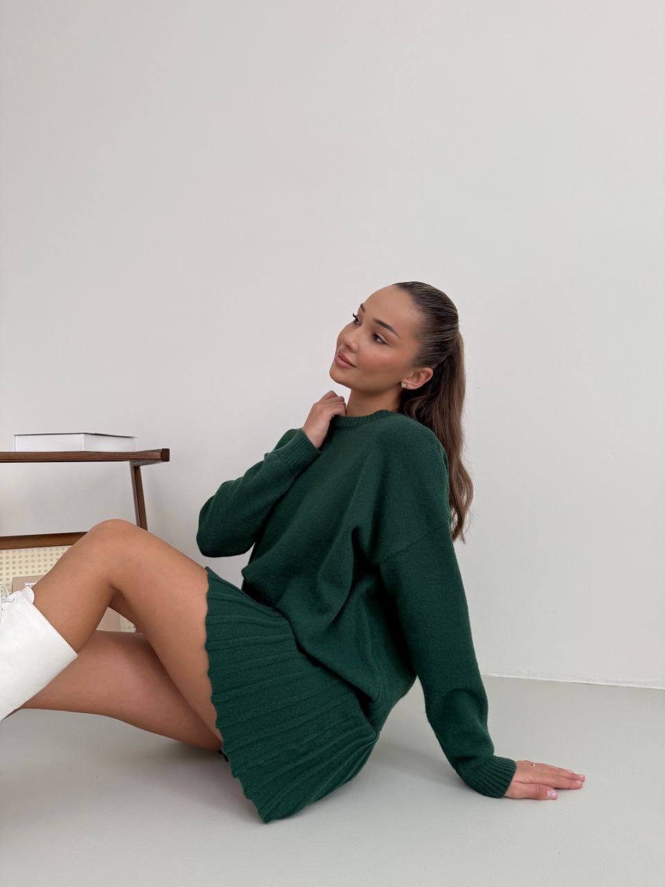 Kostým, který se skládá ze svetru a plisované sukně