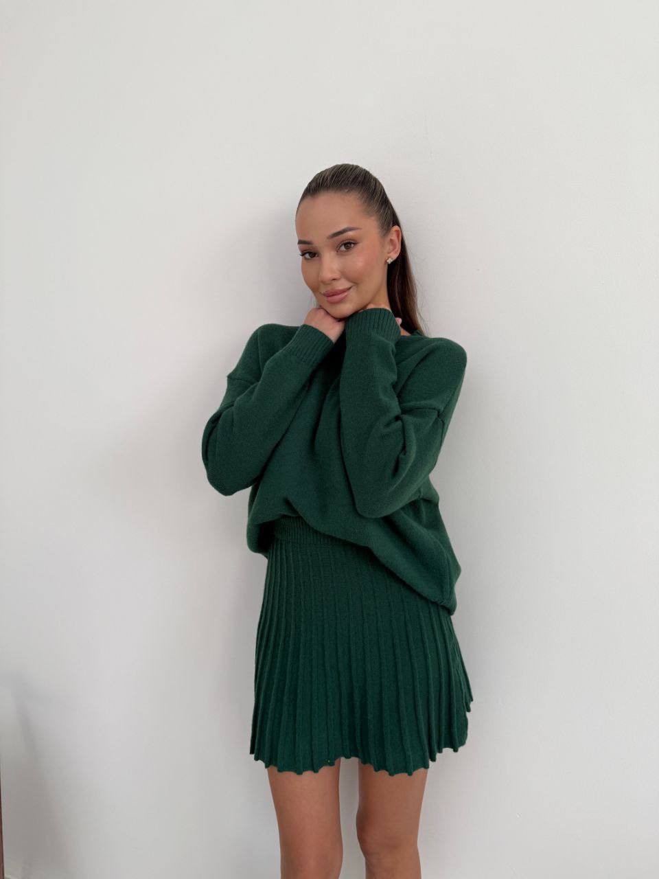 Kostým, který se skládá ze svetru a plisované sukně