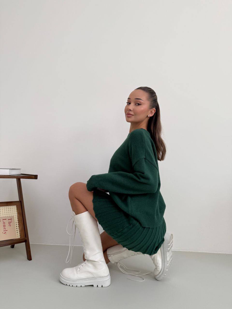 Kostým, který se skládá ze svetru a plisované sukně