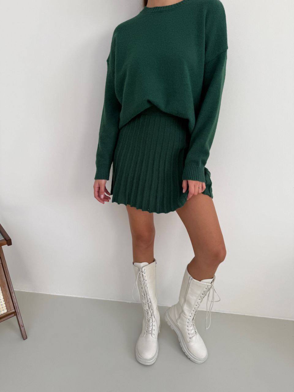 Kostým, který se skládá ze svetru a plisované sukně