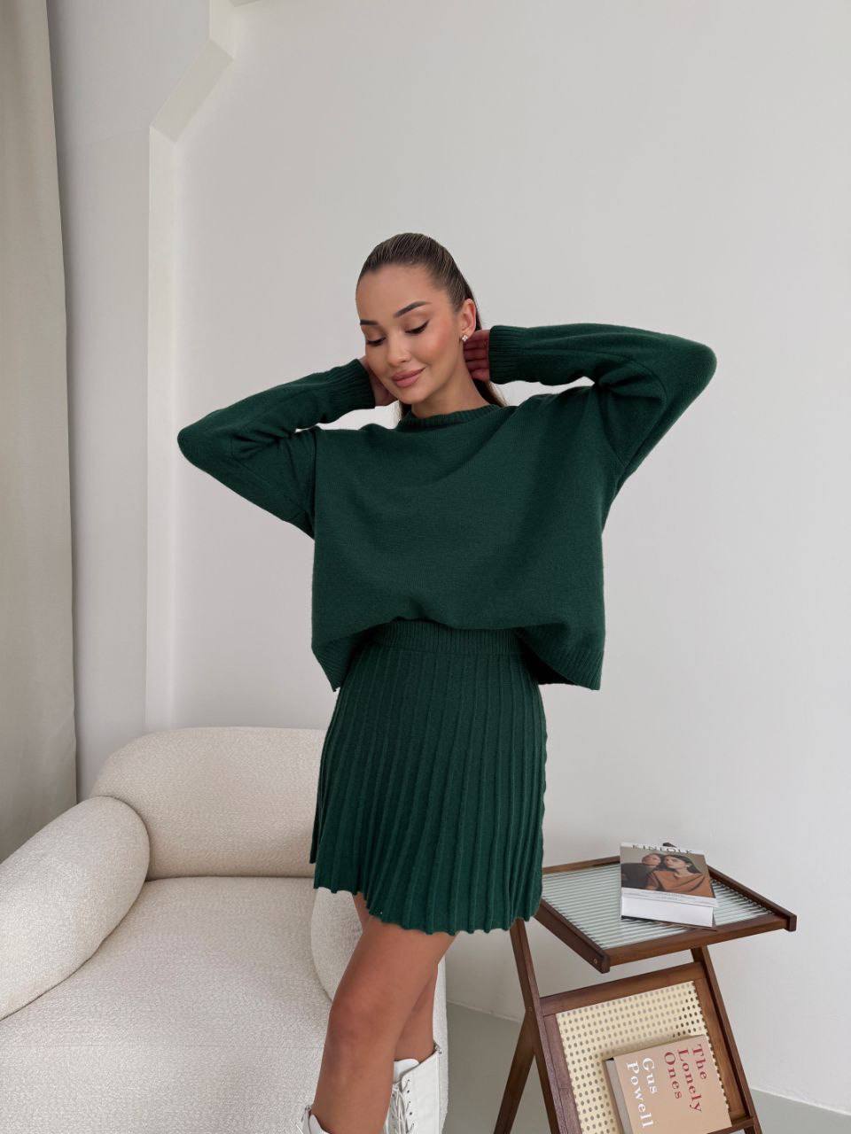 Kostým, který se skládá ze svetru a plisované sukně