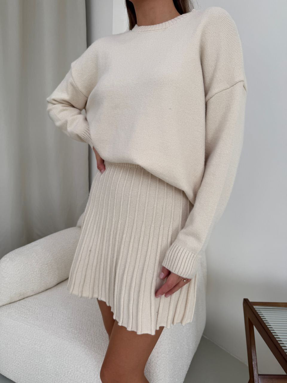 Kostým, který se skládá ze svetru a plisované sukně