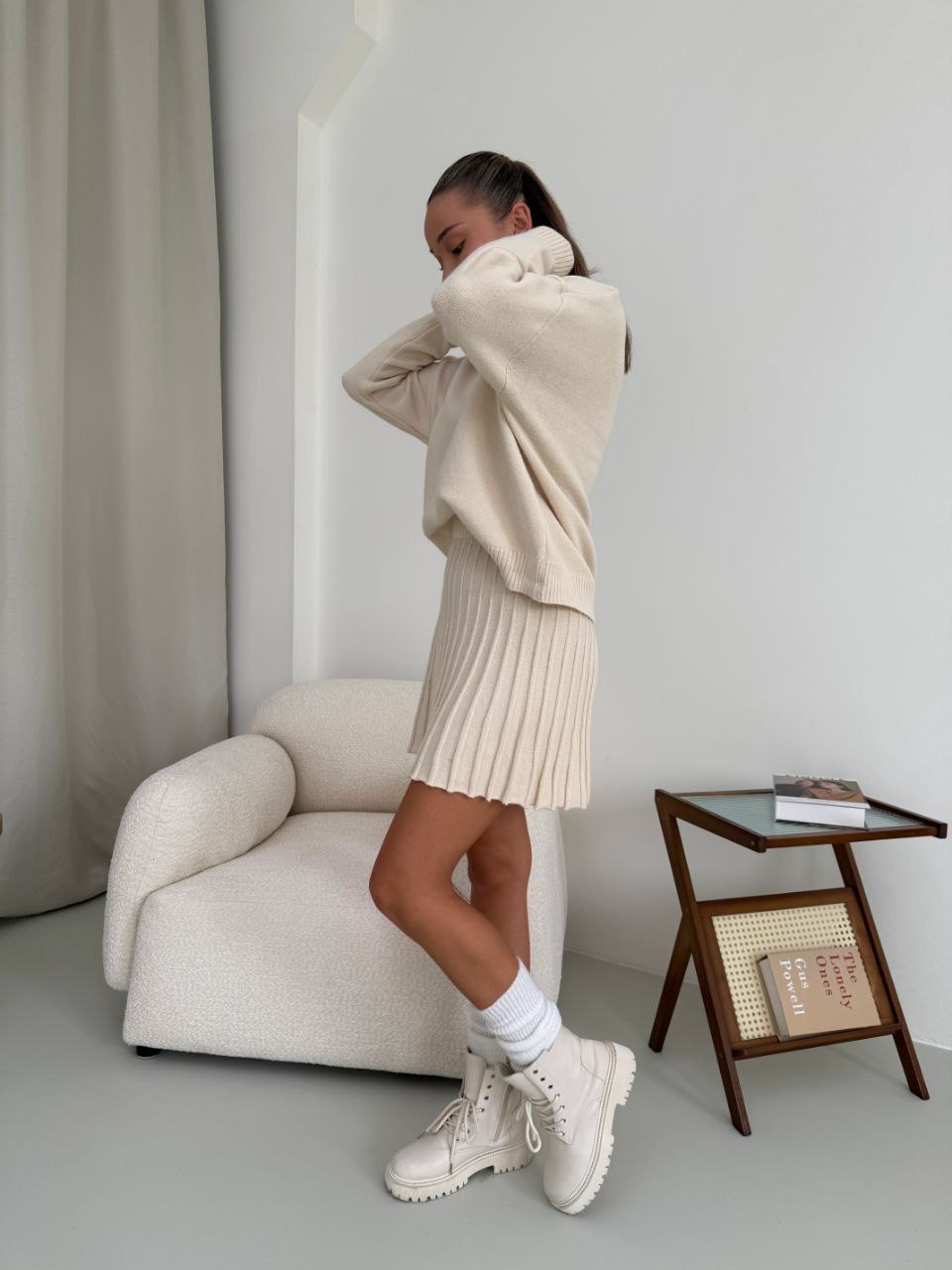 Kostým, který se skládá ze svetru a plisované sukně