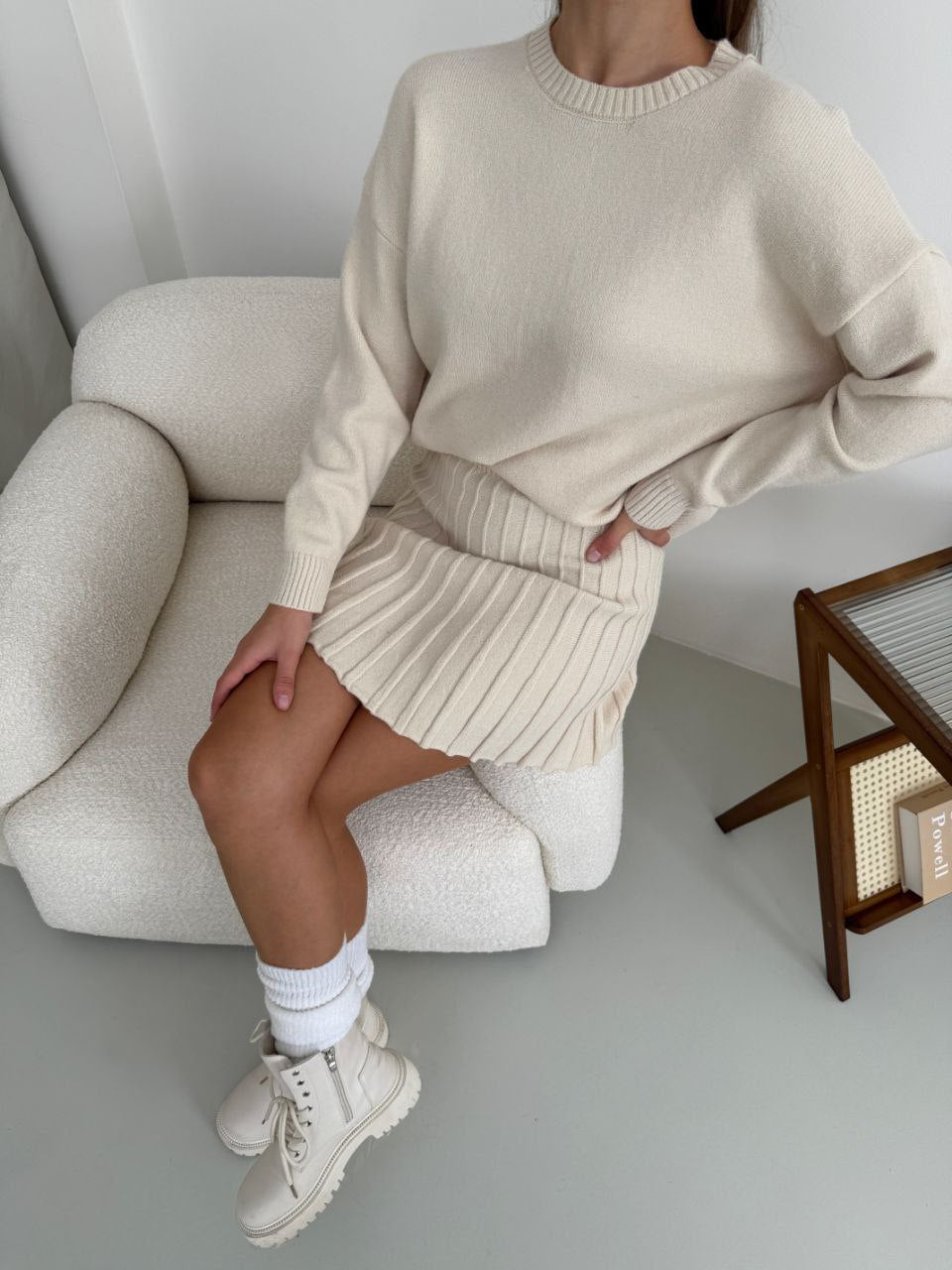 Kostým, který se skládá ze svetru a plisované sukně