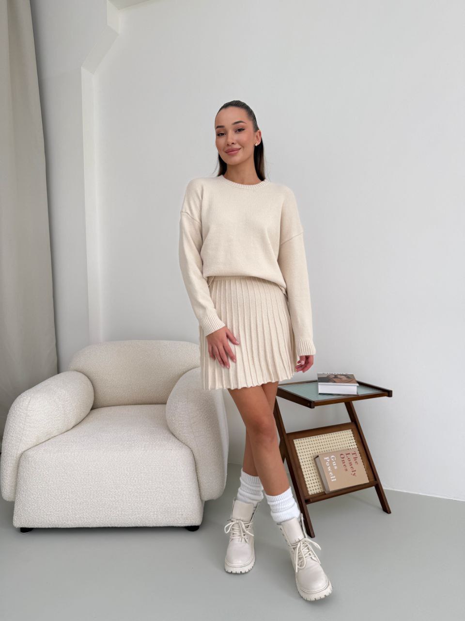 Kostým, který se skládá ze svetru a plisované sukně