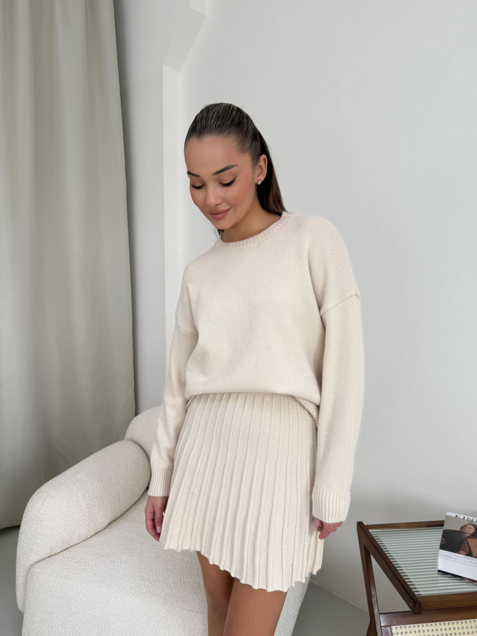 Kostým, který se skládá ze svetru a plisované sukně